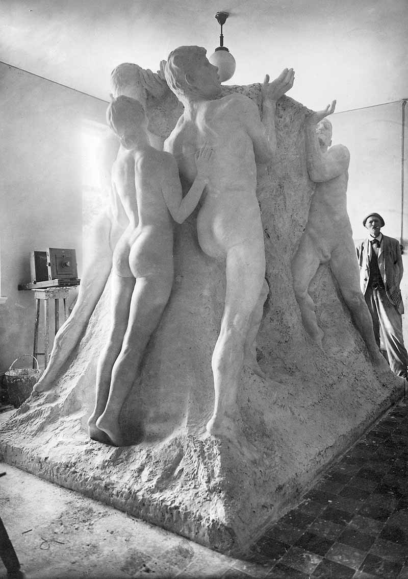 The sculpture "Arbetets Ära" in the studio in Hököpinge. In the background stands Axel Ebbe, observing his work.