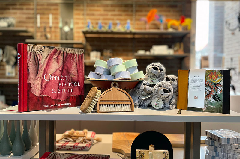 Bord med olika föremål i Trelleborgs Museums butik.