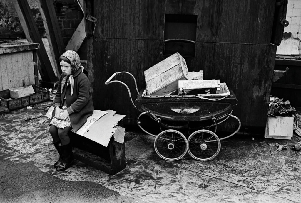 Flicka med barnvagn fylld med kartong