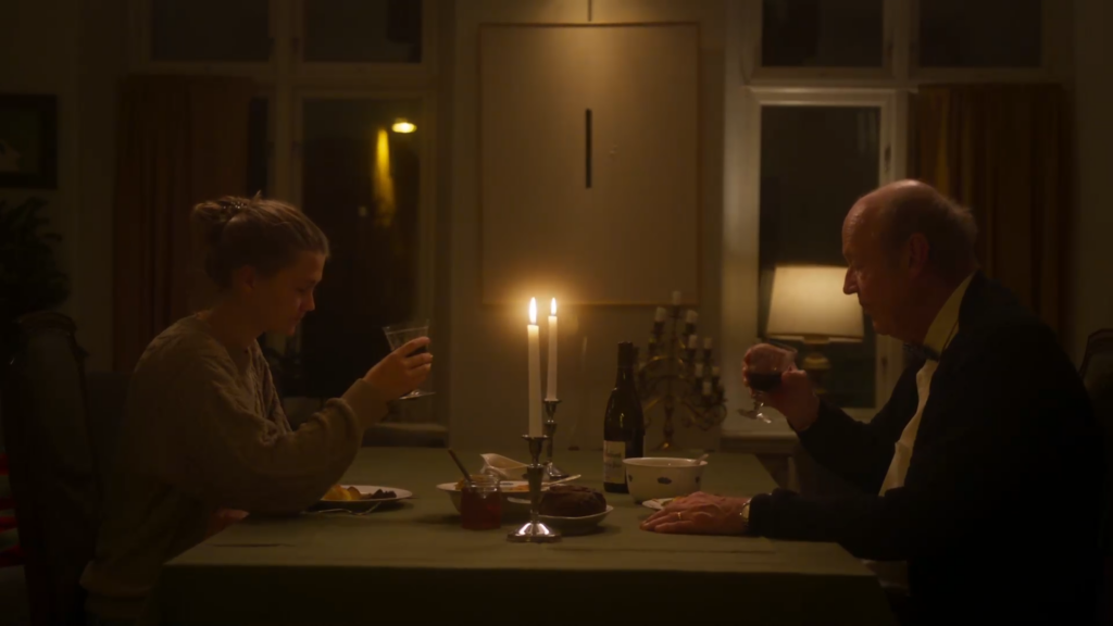 Bild från filmen "Söndagsstek” av Olof Berghe. En man och en kvinna sitter vid ett matbord belyst av ett stearinljus.