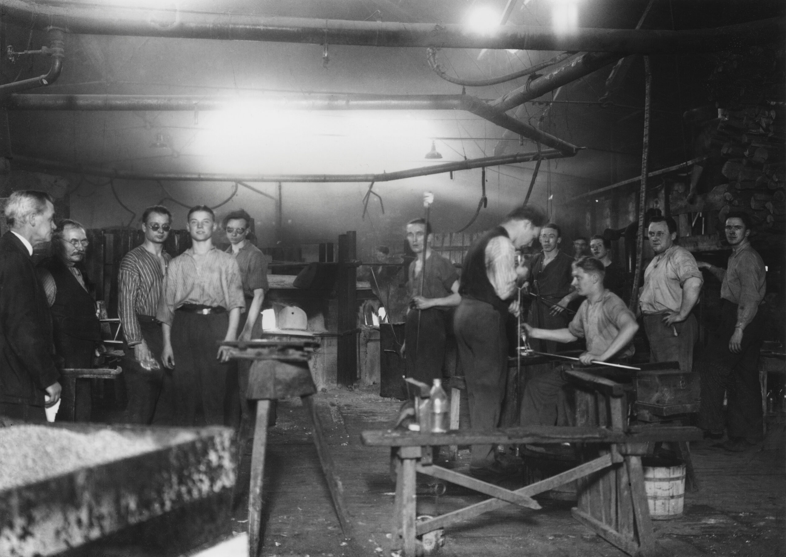 Arbetare på Trelleborgs glasindustri år 1934. Ett antal män arbetar framför ugnarna.