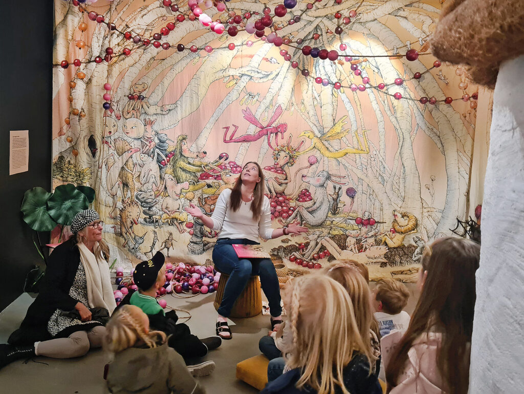Bibliotekarie läser saga för barn i Marcus Gunnar Pettertssons utställning på Trelleborgs Museum.