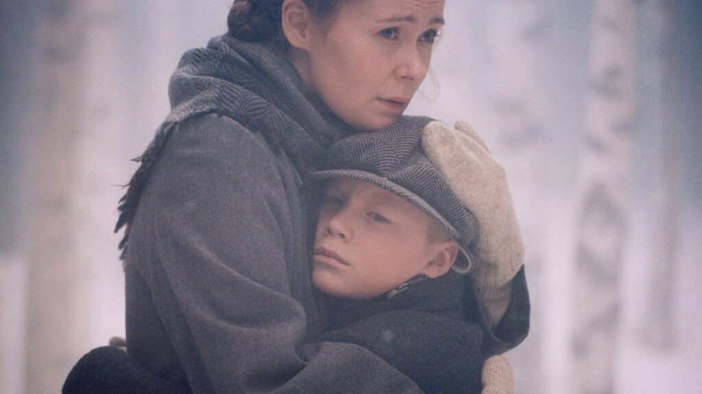 Stillbild från filmen Den bästa av mödrar. En mamma kramar en pojke i ett snöigt landskap