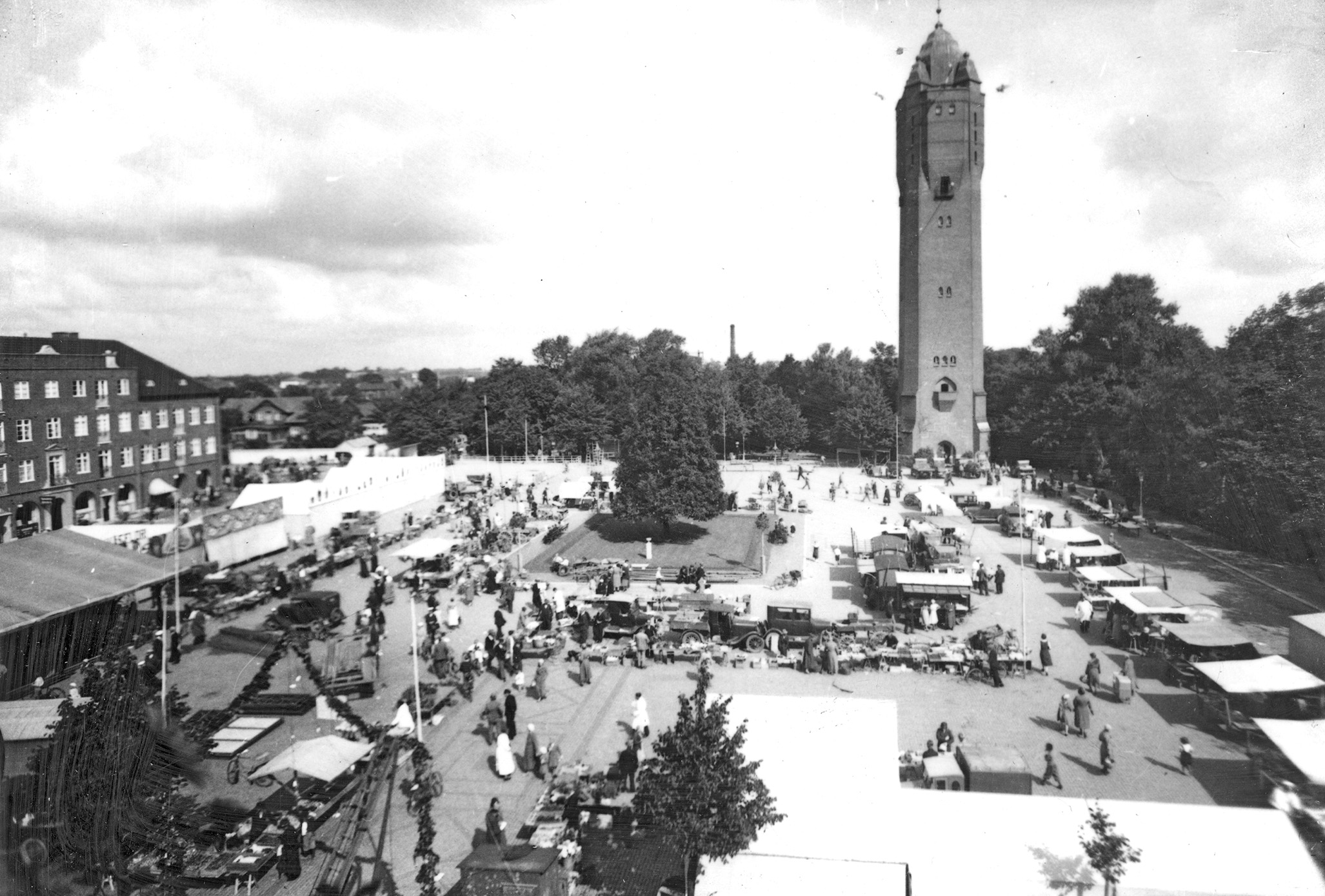 Torgfest på Stortorget i Trelleborg på 1933. På torget ser man folk och marknadsstånd. I bakgrunden vattentornet.