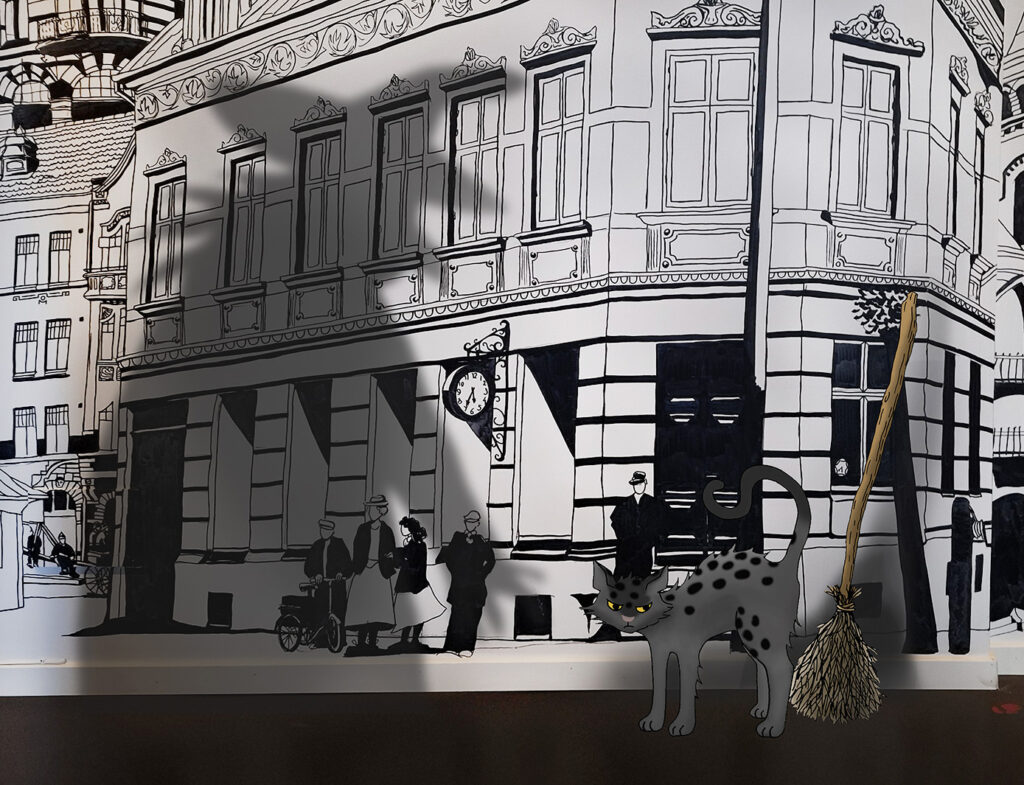 katt och kvast framför en vägg. Skuggan av en häxa.