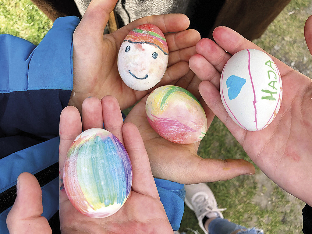Barnhänder som håller målade påskägg på Trelleborgen