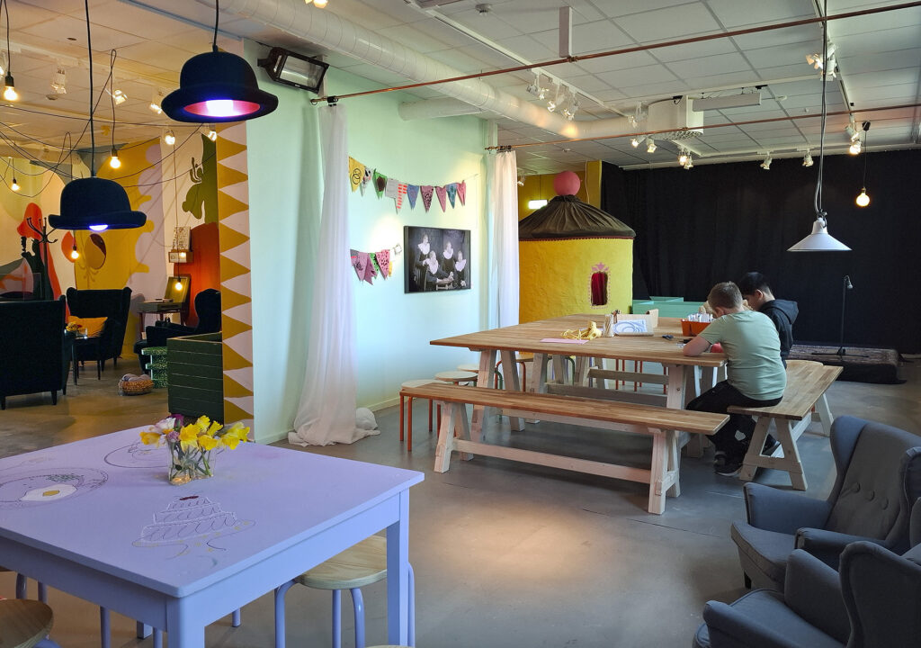 Norrummen på Trelleborgs Museum. I förgrunden ser man ett lila köksbord. Mitt i bilden ett stort bord där två pojkar sitter och målar.