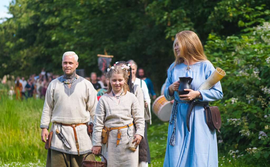 En grupp vikingaklädda människor, träd i bakgrunden