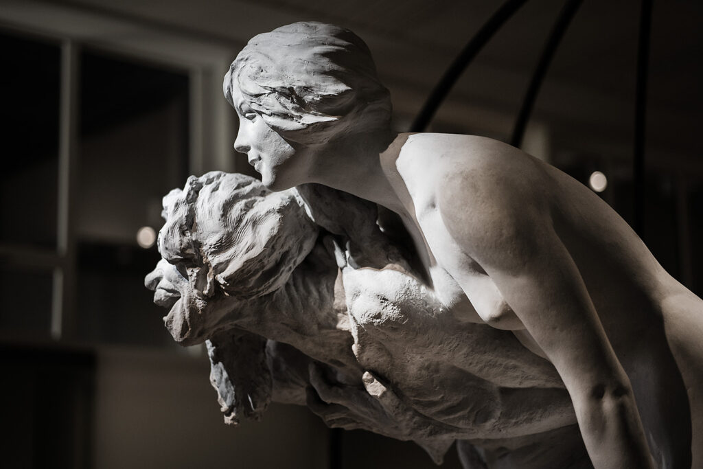 Detalj av skulpturen Skogsrået. Två kvinnor, en ung och en gammal som ser ut som en häxa.