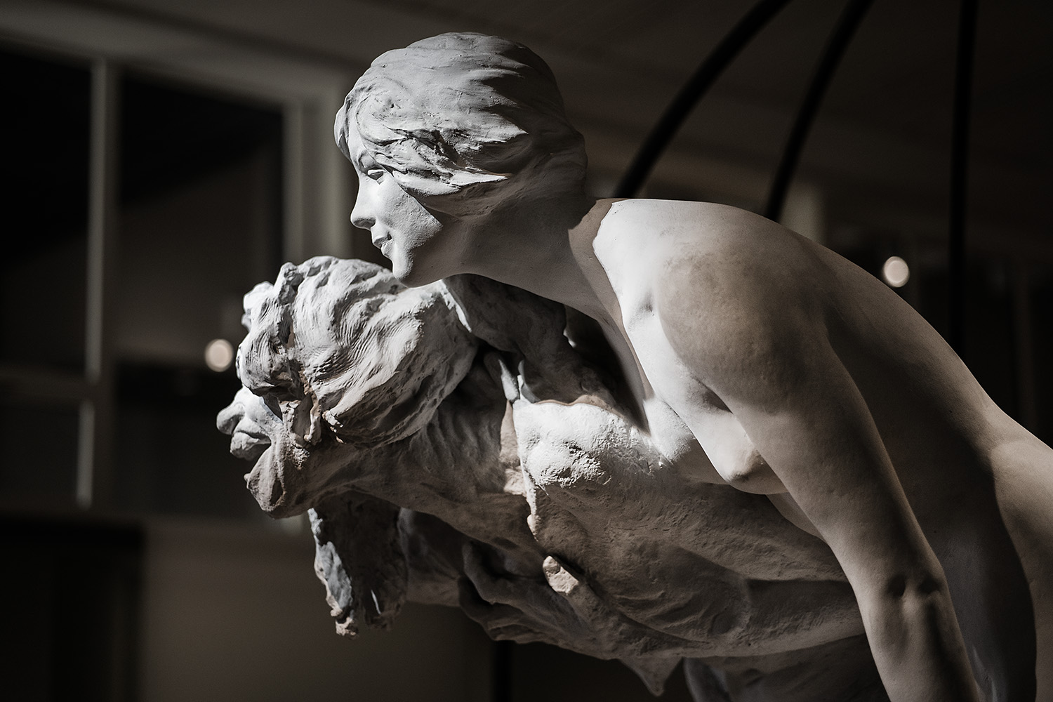 Detalj av skulpturen Skogsrået. Två kvinnor, en ung och en gammal som ser ut som en häxa.