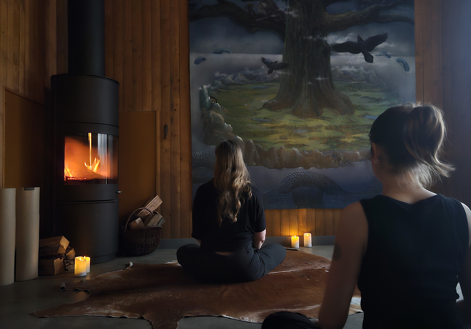 Två personer sitter med ryggen mot kameran. Levande ljus.